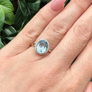 9kt Yellow Gold Ring with Oval Cut Sky Blue Topaz and Round Brilliant Cut Diamonds