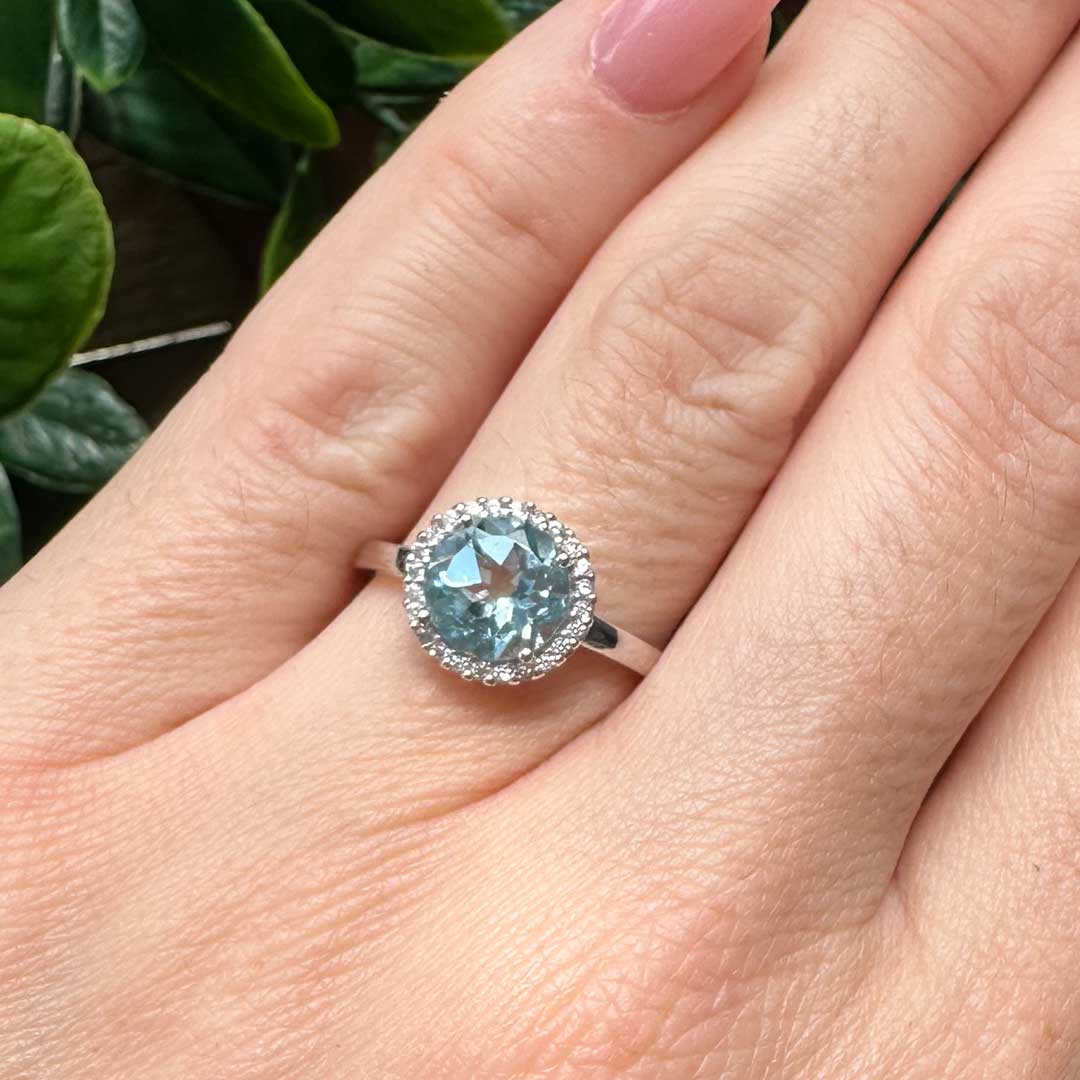 9kt White Gold Halo Ring with an 8x8mm Round Cut Sky Blue Topaz and a 0.14ct H Colour SI Clarity Round Brilliant Cut Diamond Halo