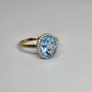 9kt Yellow Gold Ring with Oval Cut Sky Blue Topaz and Round Brilliant Cut Diamonds