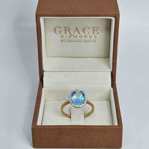 9kt Yellow Gold Ring with Oval Cut Sky Blue Topaz and Round Brilliant Cut Diamonds