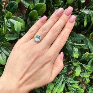 9kt Yellow Gold Ring with Oval Cut Sky Blue Topaz and Round Brilliant Cut Diamonds