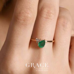 18kt Yellow Gold Ring with 7x5mm Pear Cut Emerald and 3 Round Brilliant Diamonds