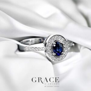 18kt White Gold Ring with 5x3mm Oval Cut Blue Sapphire and Round Brilliant Cut Diamond Halo