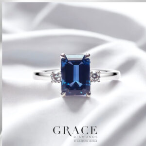 18kt White Gold Ring with 9x7mm Emerald Cut Blue Sapphire and Round Brilliant Cut Diamonds
